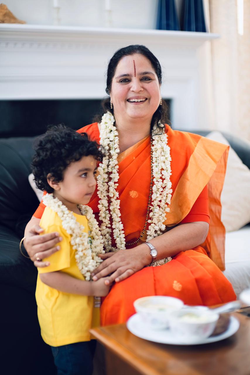 A child garlanded with jasmine, held close at a celebration